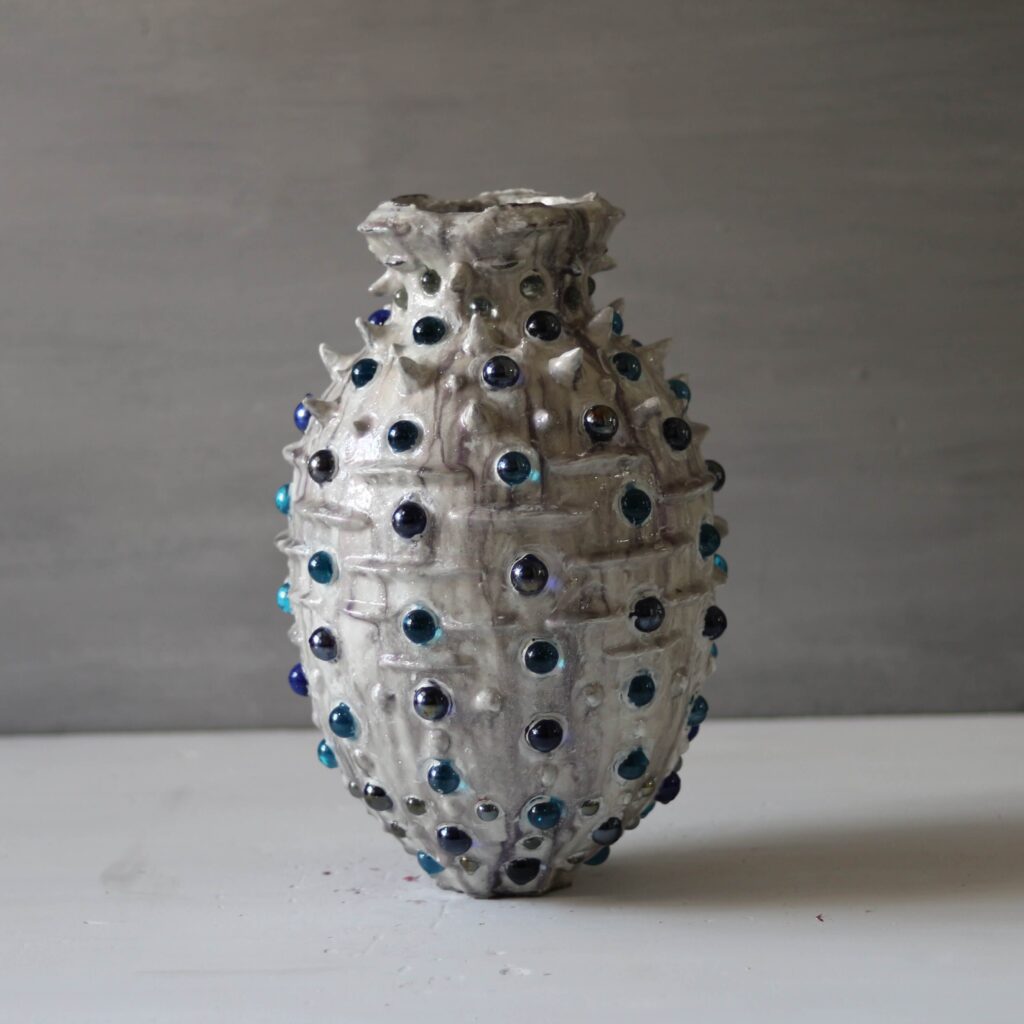 Textural mixed media vase with blue glass spheres and mineral clay.